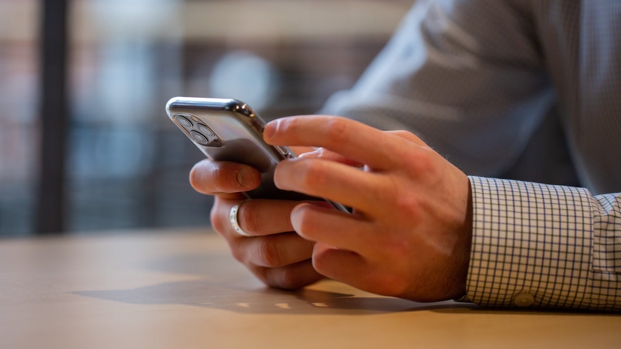 Hands holding smartphone on campus